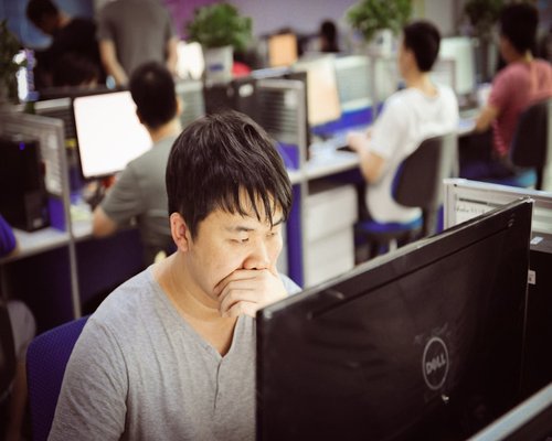 Office worker taking a short break, looking away from computer screen