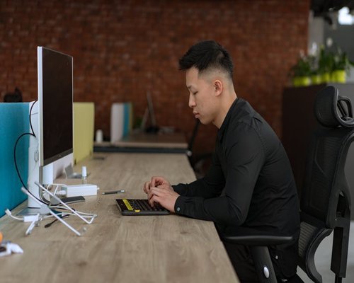 Person adjusting monitor distance for better visual posture at desk